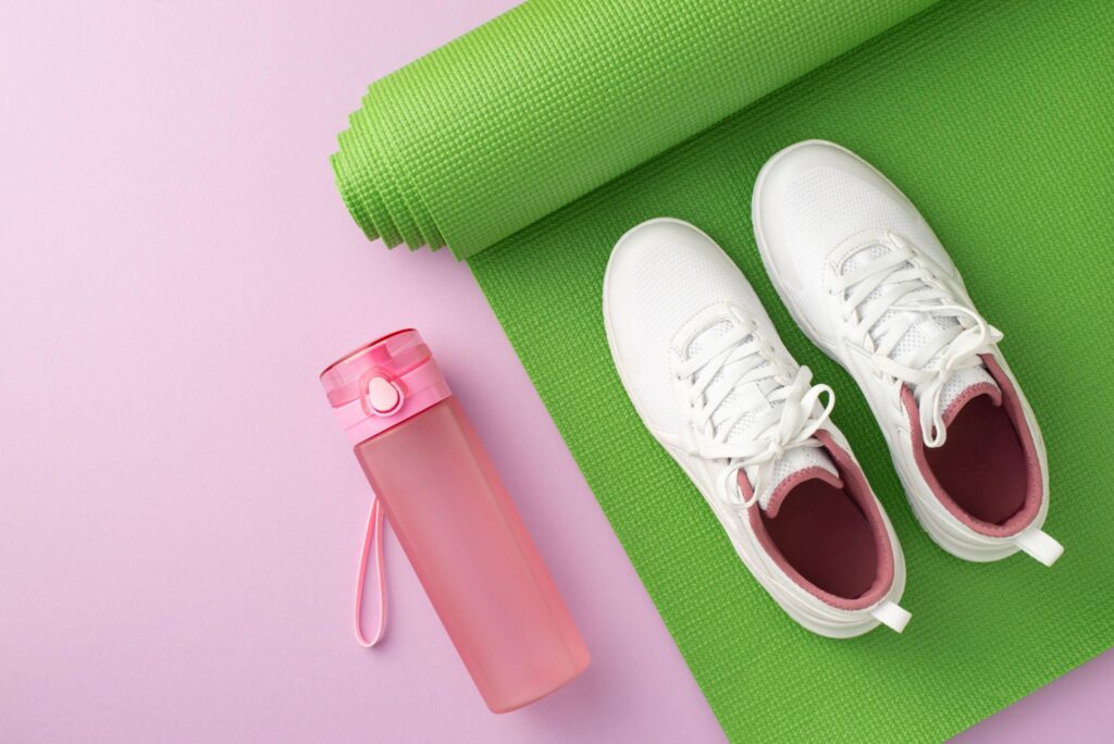 Yogamatte, Sportschuhe und Trinkflasche für gesund leben ab 40
