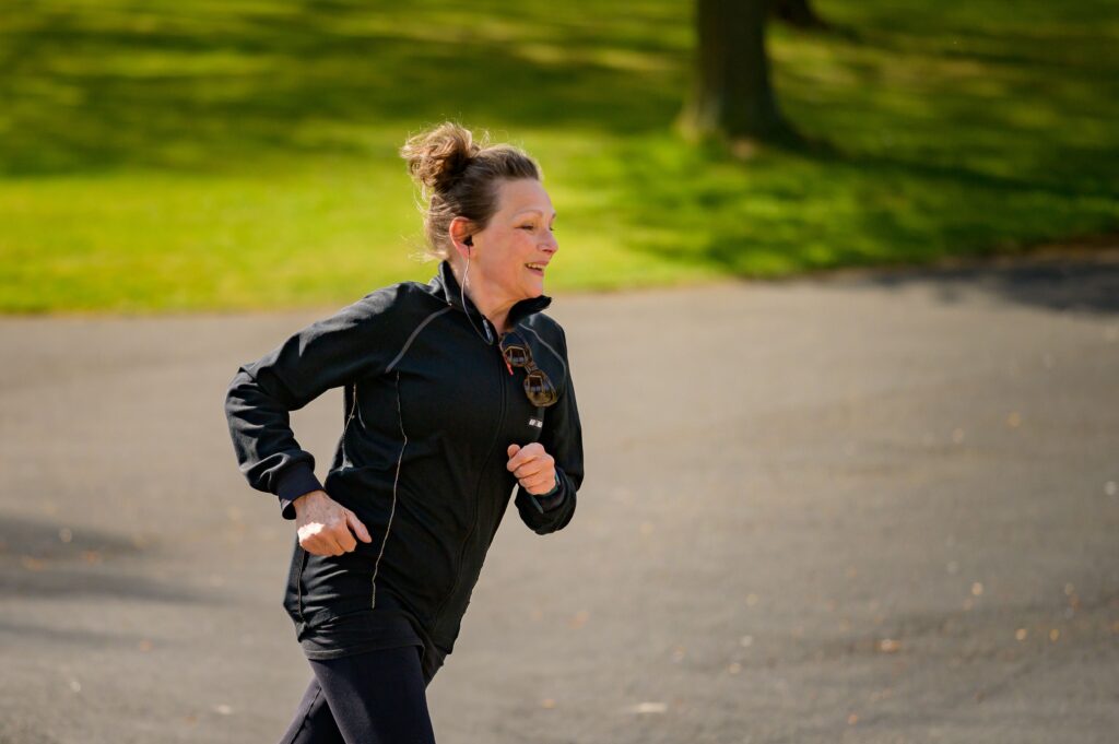 Frau beim Laufen im Park – fit und aktiv ab 40